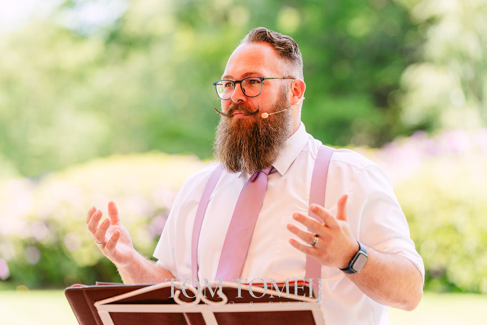 Jorg speecht in bretels tijdens een zomerse ceremonie
